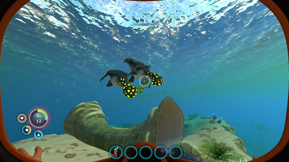 Subnautica. LadiesGamers.com. Two alien manatees with bulbous yellow tails swimming. It looks peaceful.