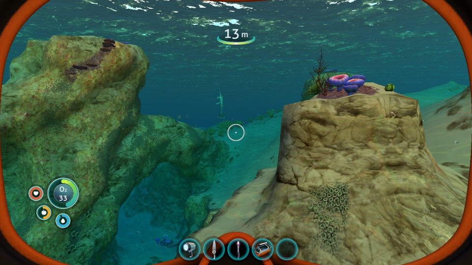 Subnautica. LadiesGamers.com. Some rocks and creatures underwater. It's a calm scene.