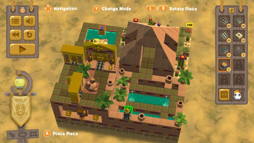 Bird's eye view of desert level 11 in construction mode. A 18x18 square diorama, with about half of the squares available to build on.