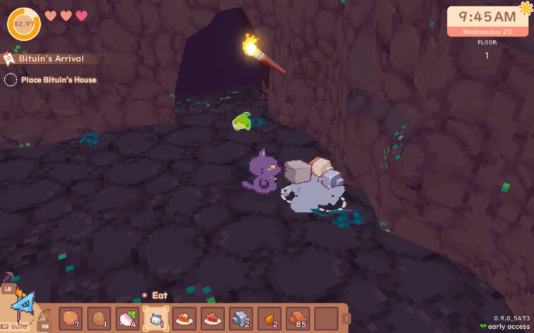 Our protagonist stands in a cave, as the icons of various materials bounces from a just-mined rock. A small green creature hovers in the air nearby.