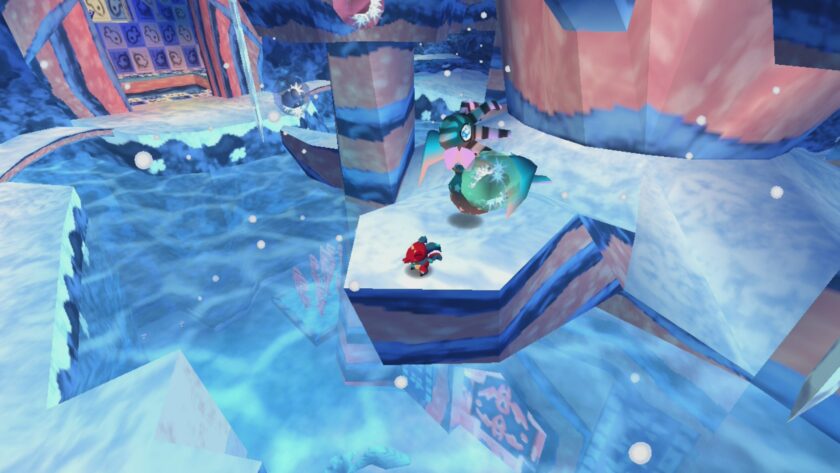 In "Cavern of Dreams", this image showcases an icy, crystalline environment with a red and blue character leaping across floating ice platforms. The scene is set against a backdrop of a dark blue sky and a vivid display of auroras. Intricate ice crystals jut out from the snowy ground, and soft snowflakes gently fall, adding to the wintry atmosphere. A turquoise and pink mechanical creature with a spherical body appears to be in motion, adding a dynamic element to the landscape. The reflective surfaces of the ice create a sense of depth and chill, emphasizing the game's frosty aesthetic. Published on: LadiesGamers.