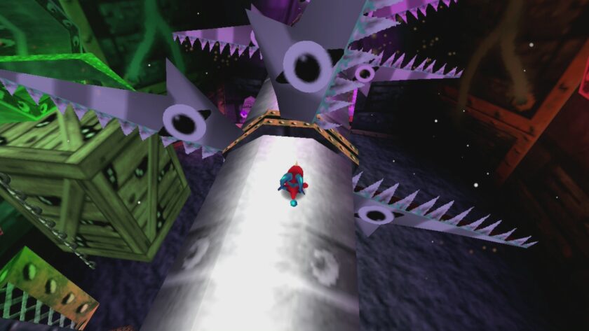 In the video game "Cavern of Dreams", the image depicts a suspenseful scene where the red and blue character runs along a narrow bridge. The bridge is flanked by menacing, trap-like structures with white, spiked teeth and glaring, cartoonish eyes, creating a sense of danger. Below, a surreal, dark abyss awaits, while above, a greenish, eerie glow emanates from the ceiling, suggesting a cavernous depth. The sharp contrast between the character's vibrant colors and the darker tones of the surroundings highlights the game's adventure theme. Published on: LadiesGamers.
