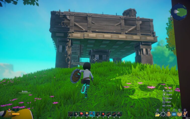 The player's character in Omega Crafter is seen approaching a raised wooden house on stilts, shield at the ready. The character is in a lush field of tall green grass interspersed with bright pink flowers. The structure is rustic with a shuttered window, exuding a sense of exploration and survival. Game controls for attack, guard, dodge, dash, and jump are visible along the bottom right, while the player's health and ability cooldowns are shown in the lower left corner. The scene is set under a clear blue sky, suggesting a serene yet adventurous gameplay experience. Published on: LadiesGamers.