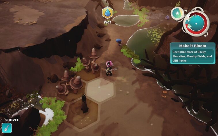 In the video game Distant Bloom, a player character wearing a pink space suit with a blue helmet wields a shovel near a wet terrain patch surrounded by brown rocky cliffs and green foliage. An in-game objective "Make it Bloom" requires revitalizing more of Rocky Shoreline, Marshy Fields, and Cliff Paths. Published on: LadiesGamers.