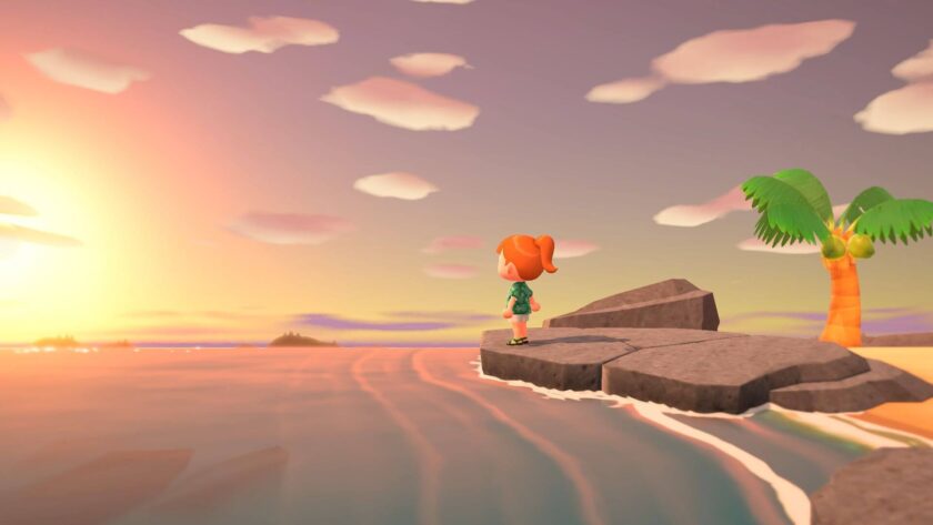 Character standing on the rocks by the sea, with the sun setting in Animal Crossing: New Horizons