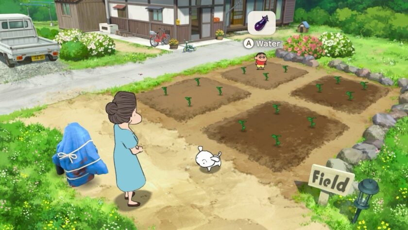 Shin-chan and his dog, Shiro, are in a garden alongside an elderly woman. Shin-chan is preparing to water the newly planted crops, while a watering can icon appears with an eggplant. The cozy setting is filled with greenery and a peaceful rural vibe. Published on: LadiesGamers.