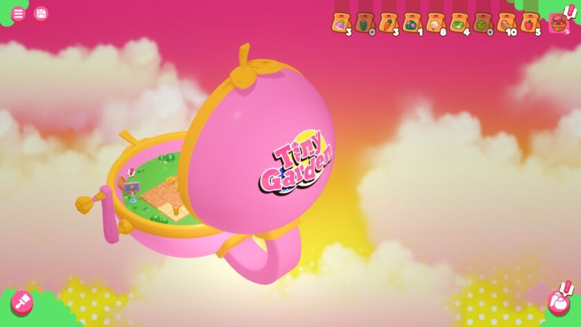 A soft, dreamy scene featuring a pink compact-shaped garden container floating in a sky filled with fluffy clouds. The container opens to reveal a tiny patch of farmland with crops and signs. The interface at the top shows seed bags, indicating gardening or farming mechanics. Published on: LadiesGamers.