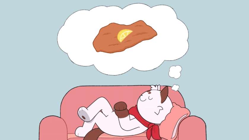 White cat with brown highlights and a red scarf lying on a sofa, with a dream bubble of a schnitzel. Published on LadiesGamers