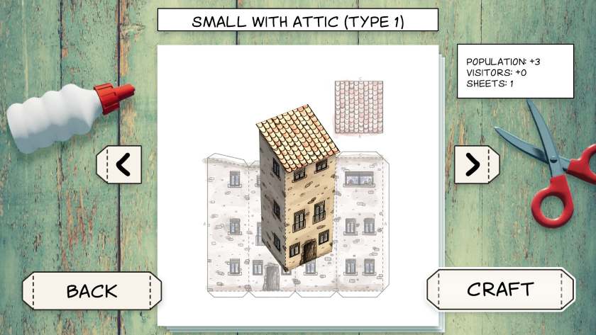 A blueprint of a folded, paper house is surrounded by the tools needed to put it together in Cutout Village.