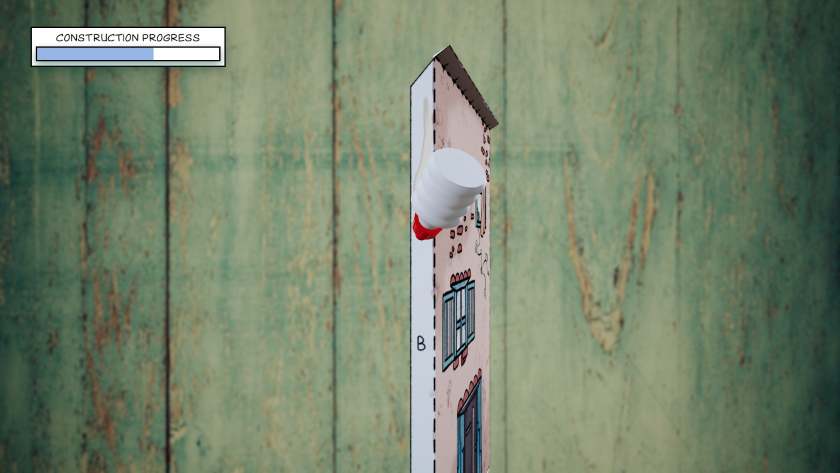 A glue bottle runs alongside a paper front of a house in Cutout Village.